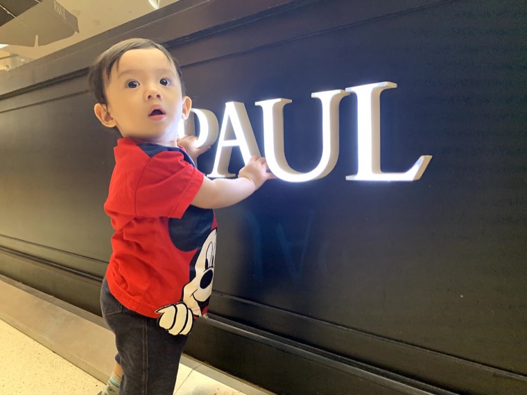 น้องพอลยืนข้างป้าย PAUL